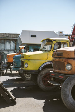 Old colorful round bonnet trucks in iranian garage
