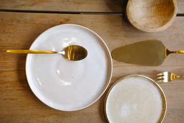Golden kitchen set on wooden tabel. White plates