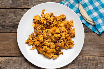 Scrambled eggs with chorizo for breakfast on wooden background. Mexican  food