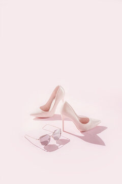 Pink female high heels/shoes on pink background.