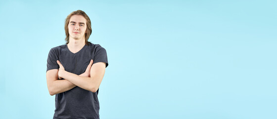 Portrait of an emotional young man in a T shirt posing for the camera isolated on a blue background