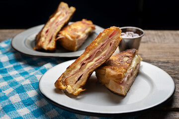Ham and melted cheese sandwich called Monte Cristo on wooden background