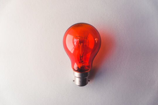 Isolated red light bulb on white background