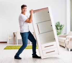 Young man moving furniture at home