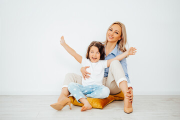 Happy family mom and daughter playing at home. Family sitting on floor and playing and hugging,...