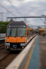 Fototapeta na wymiar Commuter Train fast moving through a Station in Sydney NSW Australia