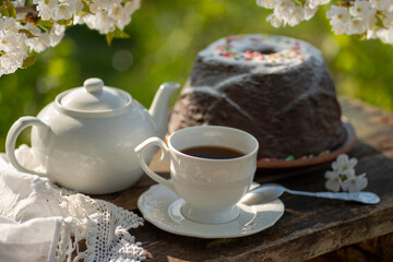 Tea set, pudding, cherry blossom branches, wooden table. Outdoor breakfast, picnic, brunch, spring mood
