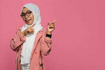 Portrait of smiling beautiful Asian woman pointing to empty space