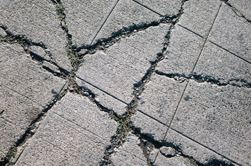 Detail of cracked and worn urban sidewalk