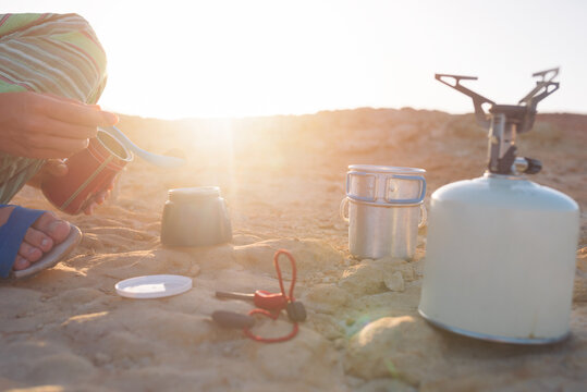 Woman preparing coffee outddor on the beach