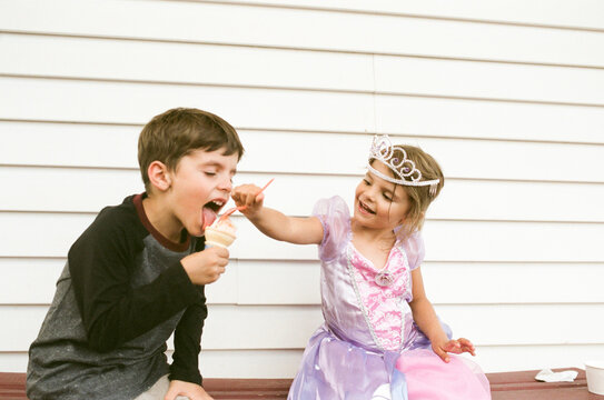 siblings sharing ice cream