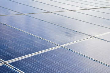 Closeup view of photovoltaic panels surface which installed on the building's roof after washing and cleaning by the company's staffs in the afternoon of the day.