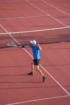 Male tennis player hitting the ball with backhand stroke techinq