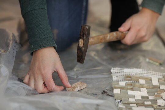 Crop woman cracking piece for mosaic