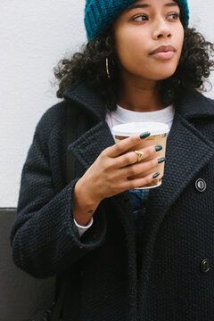 Young woman drinking coffee outside