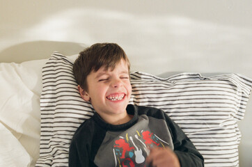 boy laughs with eyes closed