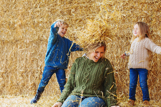 Mother and kids having fun on a haystack.