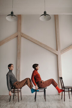 Models posing on chairs in studio