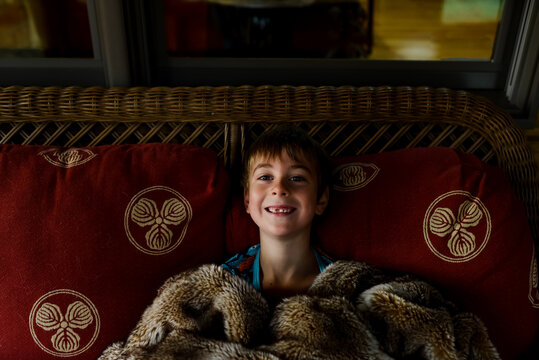little boy with warm blanket and toothless grin