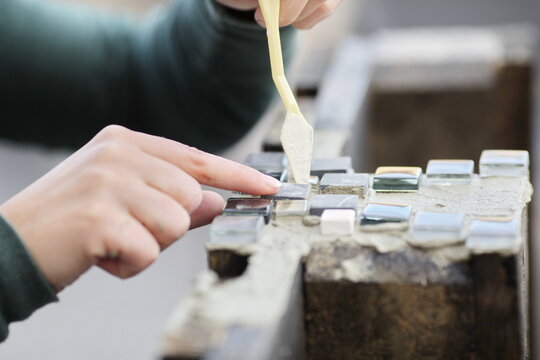 Woman doing handicraft with tiles