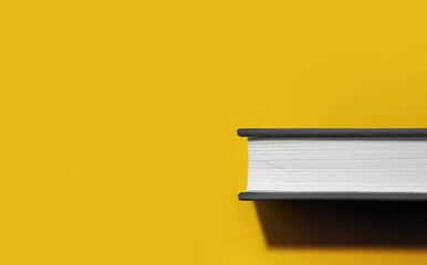 book in gray hardcover with white blank sheets with hard trend shadow on bright Illuminating yellow background, book day 2021 concept, colors of year application, selective focus