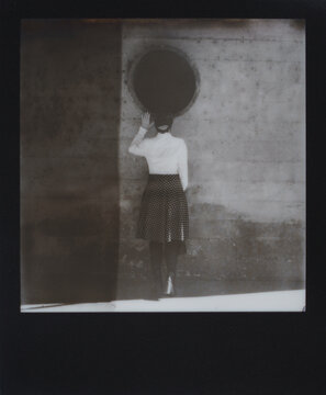 Polaroid of Woman Looking into Large Drain Pipe