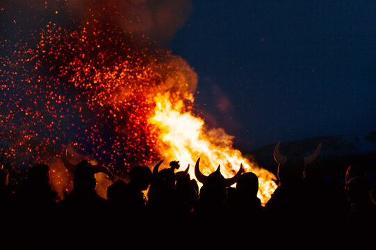 A crowd of people around a bonfire at night
