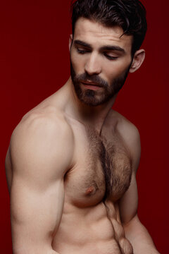 Handsome shirtless strong man portrait over red background