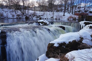 Fototapeta na wymiar Winter view of the Great Falls of the Passaic River, part of the Paterson Great Falls National Historical Park in New Jersey, United States, after a snow storm.