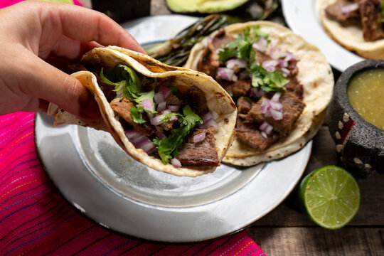 Grilled beef steak tacos on wooden background. Mexican food