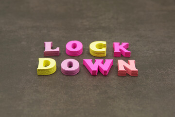 Coronavirus world lockdown. Word LOCKDOWN laid out of wooden letters on brown background. Imposition of stringent restrictions on travel, social interaction. Medical and covid-19 pandemic concept.
