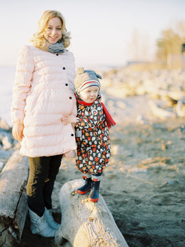 Pregnant woman with adorable son on beach