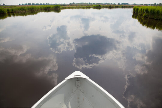 Reflection of clouds in the water, as seen from a small boat