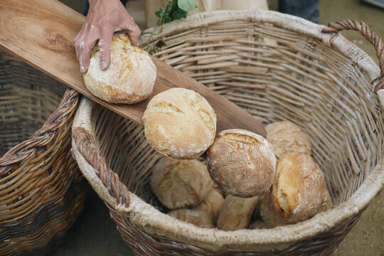 Baker filling a bread basket with fresh loaves