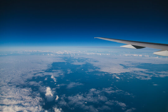 Detail of an Airplane Wing Over a Blue Cloudscape