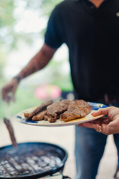 Meat on a plate with the barbecue in the background