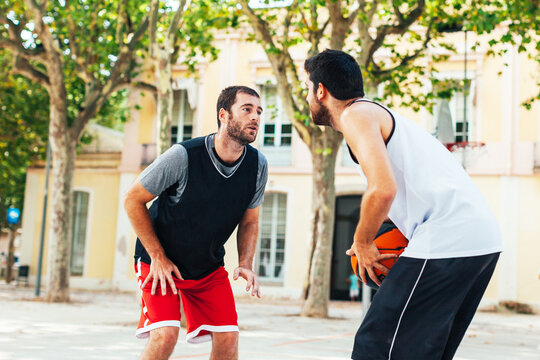 Two young basketball players training on a street court.