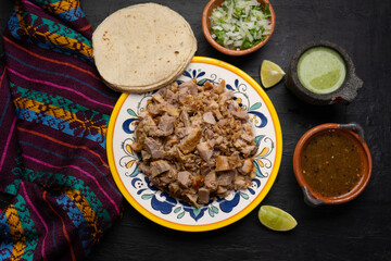 Confit pork called carnitas on dark background. Mexican food