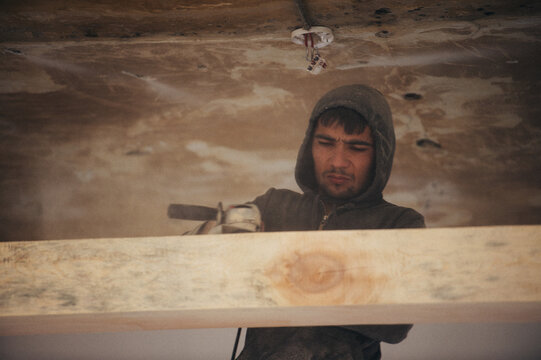 Carpenter sanding a wood with sander