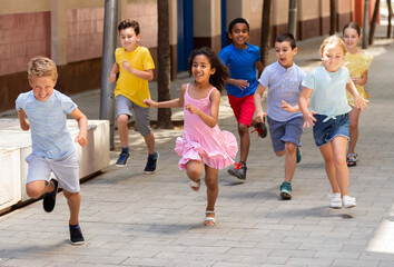 Fototapeta premium Happy children running in race and laughing outdoors at sunny day