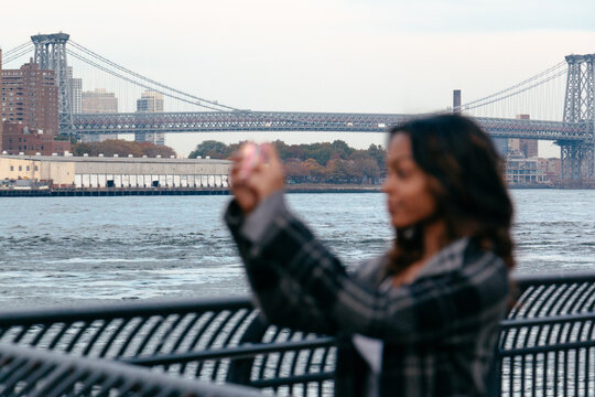 Woman taking photos with mobile phone in New York