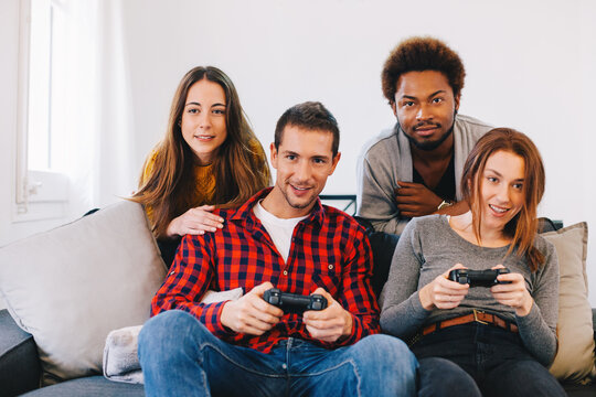 Group of young friends playing video games at home.
