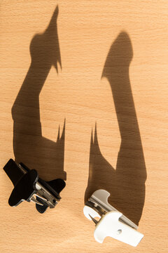 Two staple removers casting long shadows on a desk