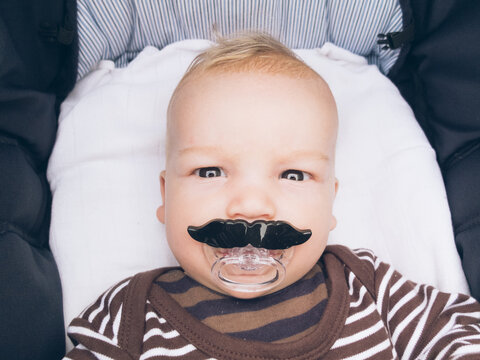 Baby with moustache pacifier