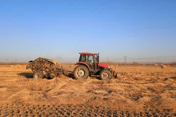 Obraz premium farmers use agricultural machinery to compress rice straw and bundle them on a farm, LUANNAN COUNTY, Hebei Province, China