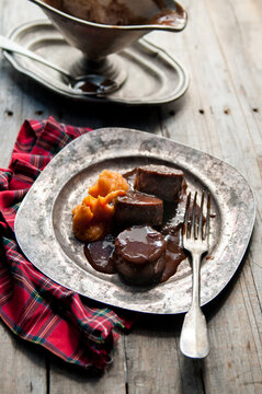 Stewed bull tail (oxtail) with sweet potatoe on a vintage silver plate
