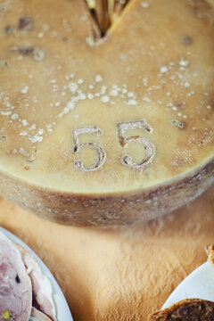 Overhead shot of entire round seasoned cheese shape on furnished table