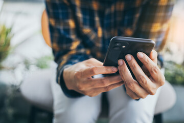 using cell phone hand holding mobile texting message contact us.chatting,search internet information in office.technology device communication connecting