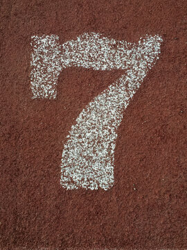white number seven painted on an running track