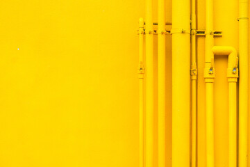 Many yellow pipes arranging in line on yellow wall